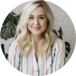 woman with blonde hair wearing a striped blouse and smiling to the camera