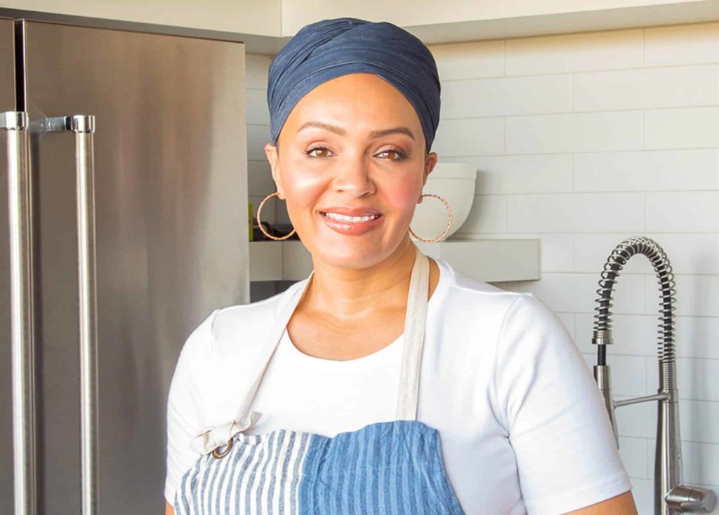 woman in an apron in the kitchen smiling