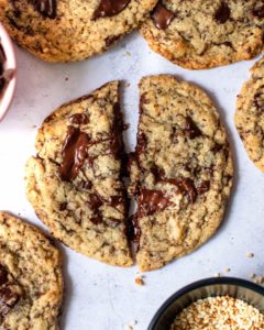 chocolate chip cookie sliced in half on a white stone surface