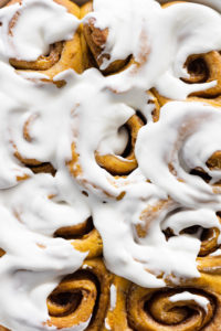 close up of cinnamon rolls covered in frosting