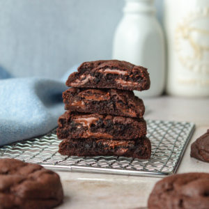chocoalte cookies cut in half and stacked on top of a cooling rack