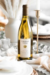 bottle of wine on a table with a gold candlestick