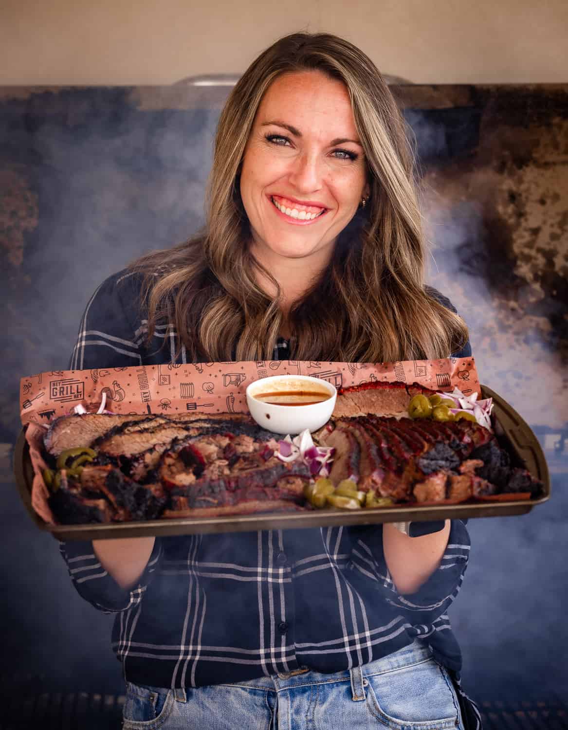 woman holding a board with meat