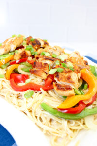 close up of pasta with chicken, bell peppers, and onions