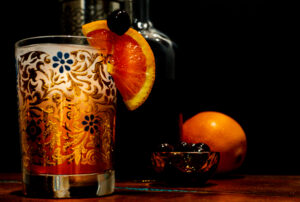 old fashioned drink in a glass cup with a slice of fruit