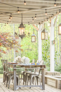 table on a patio with chairs and lanterns