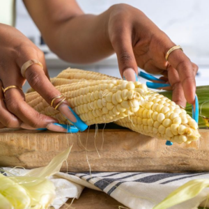 Close up of woman's hands with corn on the cob