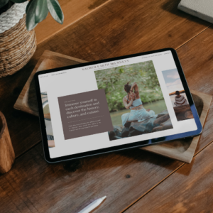 A tablet on a wooden table displaying a travel website for Sacred Earth Journeys, featuring a serene image of a woman sitting in nature, with a promotional blurb about cultural and immersive travel experiences.