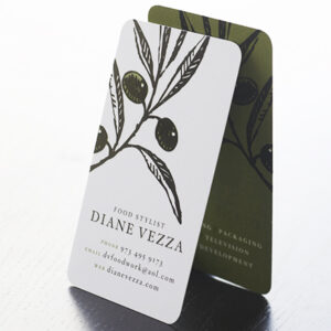 A stylish business card for food stylist Diane Vezza, featuring an olive branch illustration with contact information displayed in elegant typography, set against a dark olive background.