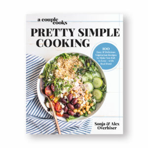 Cover of the book 'Pretty Simple Cooking' by Sonja and Alex Overhiser, showing a colorful bowl of a fresh salad with chickpeas, tomatoes, cucumbers, olives, and grains, alongside a tagline promoting easy vegetarian recipes.