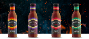 Four bottles of Ponder BBQ sauce with colorful geometric labels featuring different flavors: Hickory & Molasses, Pecan & Honey, Mesquite & Maple, and Oak & Sorghum, set against a dark smoky background with glowing embers.