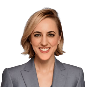a woman with short blonde hair wearing a gray blazer smiles in front of a white background